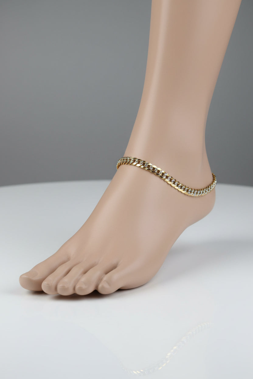 Gold chain displayed in front of a mirror with blurred store interior.